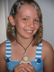 A happy girl smiling as she holds a clay model that was used as one of many tools to help overcome her learning disability